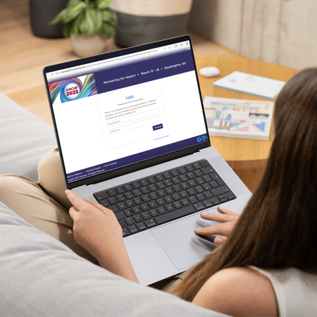 Person sitting on couch browsing the AMCHP 2025 conference platform. 