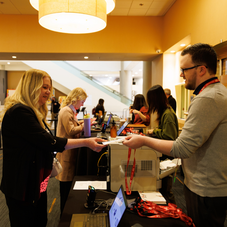 AMCHP staff member helping AMCHP 2024 participant at registration. 