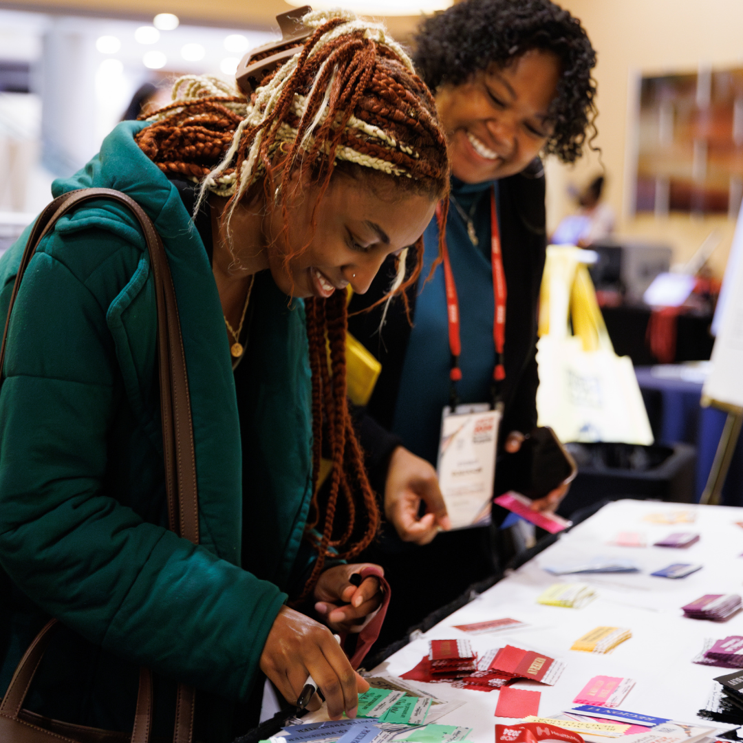 AMCHP conference participants selecting their badges at the registration table.