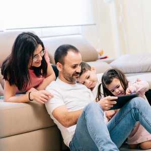 Family in living room looking at a tablet
