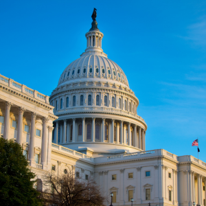 The United States Capitol building in Washington, D.C., with the dome illuminated by sunlight against a clear blue sky.