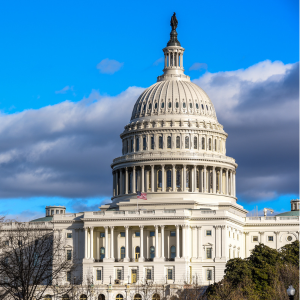 The United States Capitol building in Washington, D.C., with a bright blue sky and scattered clouds in the background.