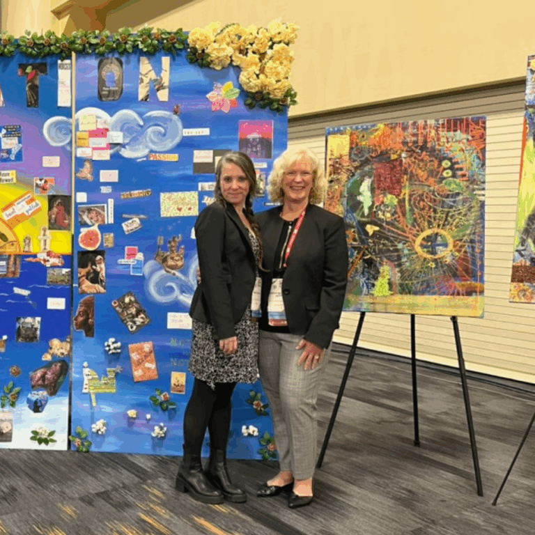 Two women, including Cathy Butler-Witt, pose and smile at the camera at the AMCHP Conference.