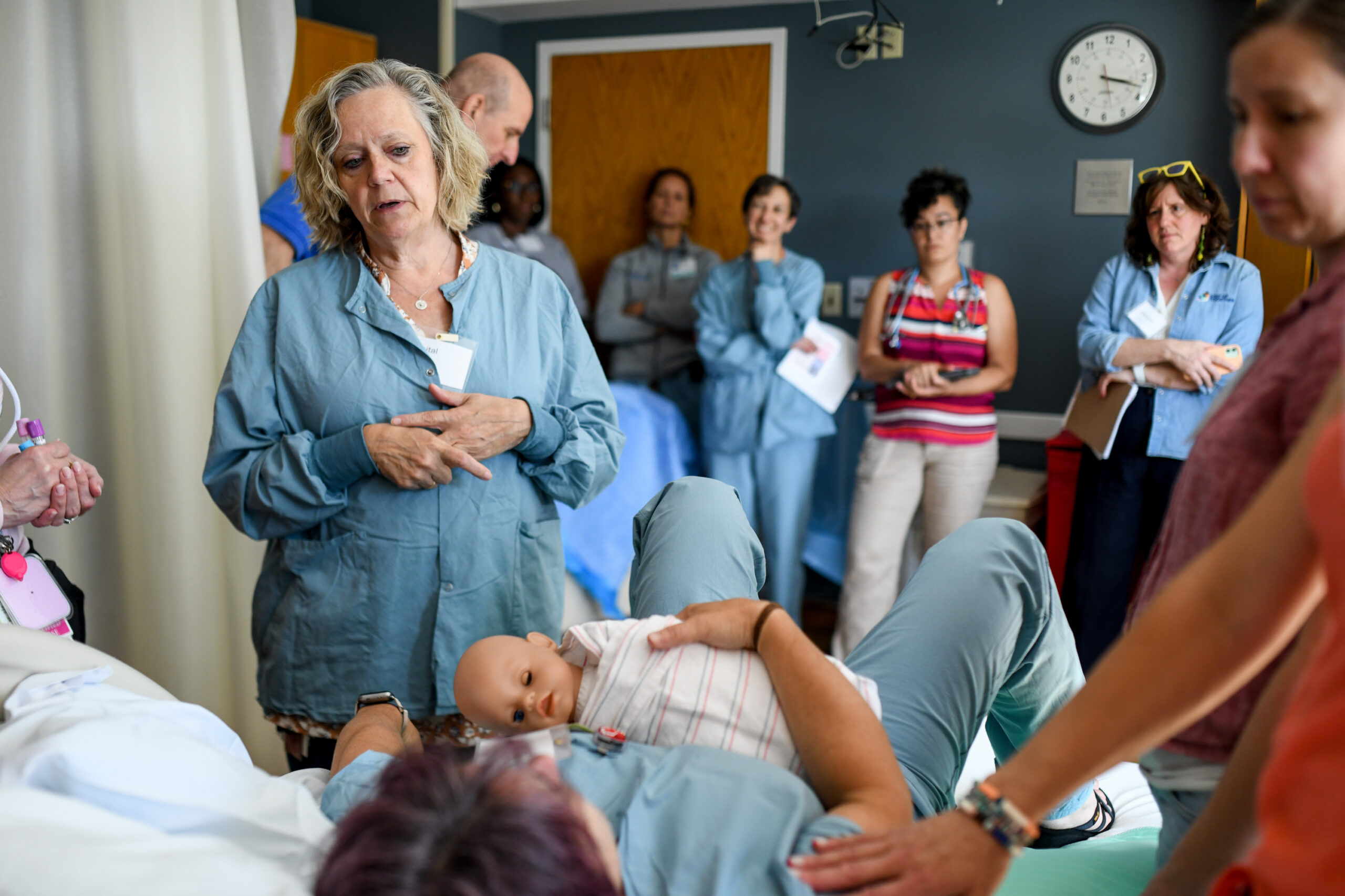 Providers standing in a medical exam room with a patient